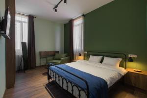 una camera da letto con un letto e una parete verde di Mtevino a Khashmi