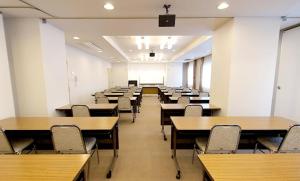 a classroom with rows of tables and chairs at Takamatsu City Hotel in Takamatsu