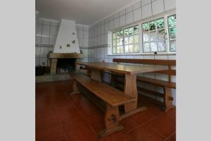 eine Küche mit einem Holztisch und einer Bank in der Unterkunft Douro Valley - Casa do Campo Resende in Covelas