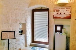 uma cozinha com uma janela e um frigorífico branco em Casa del Maestro em Cisternino
