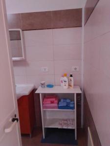 a small bathroom with a sink and a table at Camera Noemi in Torre Lapillo +10 photos