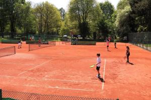 a group of people playing tennis on a tennis court at Maisonette am Belchen in Bad Krozingen