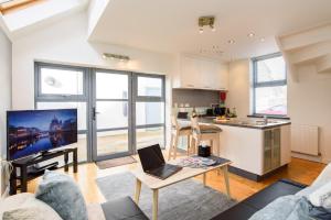a kitchen and a living room with a laptop on a table at City Retreat, 2 Bed House with Cloudstream Hot Tub in Cardiff
