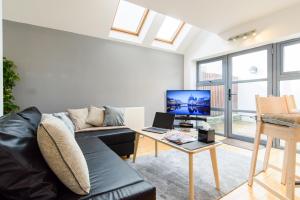 uma sala de estar com um sofá e uma mesa em City Retreat, 2 Bed House with Cloudstream Hot Tub em Cardiff