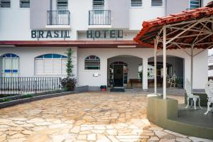 een hotelgebouw met een stenen patio ervoor bij Brasil Hotel in Três Pontas