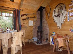 comedor con fogones en una cabaña de madera en Chambre d'hôte atypique "trappeur" West little ranch, en Guiscriff