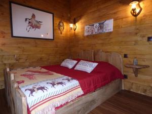 1 dormitorio con 1 cama en una habitación con paredes de madera en Chambre d'hôte atypique "trappeur" West little ranch, en Guiscriff
