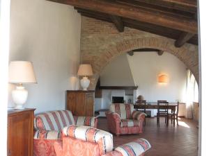 ein Wohnzimmer mit 2 Stühlen und einem Tisch in der Unterkunft Agriturismo Chieteno con piscina - Cetona in Cetona