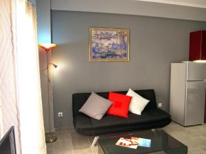 a living room with a black couch with red pillows at Ideally Situated Corfu Old Town Studio in Corfu Town