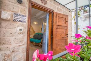 a door leading into a room with pink flowers at Trulli&Dimore - Casa Reina in Polignano a Mare