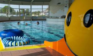 a swimming pool with people in the water at 17e straatje in Elburg