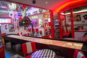Vettebar Guesthouse في Gislinge: مطعم فيه بار الكراسي حمراء وبيضاء