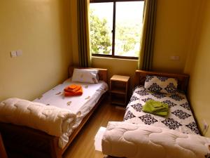 two beds in a room with a window at Enjivai Hostel in Arusha
