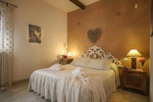 een slaapkamer met een wit bed met een hart aan de muur bij TD Casa Torchiano Hilltop Pool with Sea View in Monopoli