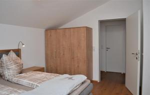 1 dormitorio con 1 cama y armario de madera en Ferienwohnung mit Seeblick, Unterach am Attersse en Unterach am Attersee