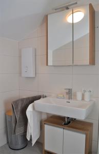 a bathroom with a white sink and a mirror at Ferienwohnung mit Seeblick, Unterach am Attersse in Unterach am Attersee