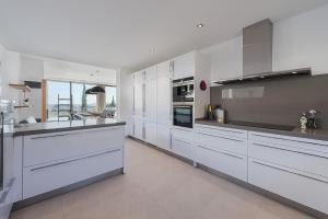 una gran cocina blanca con armarios y electrodomésticos blancos en Luxury Villa Phoenix, en Puerto Pollensa