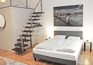 sypialnia z łóżkiem i spiralnymi schodami w obiekcie Luxury new apartment with gallery at Dob street nearby Gozsdu court w Budapeszcie