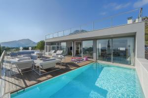 Una casa con piscina y muebles de patio. en Luxury Villa Phoenix, en Puerto Pollensa