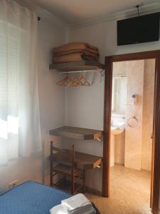 a room with a bed and a dresser at Pensión Portomiño in Portomarin
