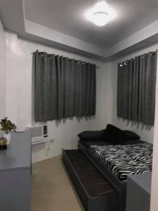 um quarto com uma cama, uma secretária e cortinas em Casa Dee Leticia em Sibalom