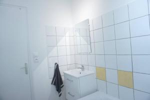 biała łazienka z umywalką i toaletą w obiekcie Studio Cosy 2 Proche gare w mieście Saint-Quentin