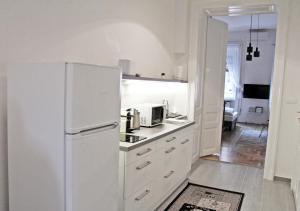 - białą kuchnię z białą lodówką w pokoju w obiekcie Luxury new apartment with gallery at Dob street nearby Gozsdu court w Budapeszcie