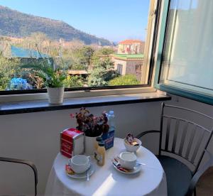 une table avec deux tasses de café et une fenêtre dans l'établissement Itaca B&B, à Piano di Sorrento