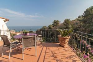 uma varanda com uma mesa e cadeiras e o oceano em Casa Bellavista em Diano Marina