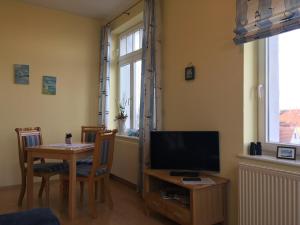 a living room with a television and a table with chairs at Hotel Ambiente in Brake