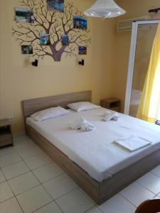 a bedroom with a bed with a tree on the wall at Asteras Studios in Argostoli