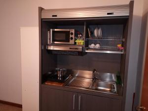 a kitchen with a sink and a microwave at Ca' Del Sasso in Verona