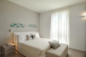 阿拉西奧的住宿－Residence San Marco Suites&Apartments Alassio，卧室配有白色的床和窗户。