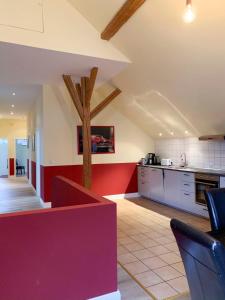 eine große Küche mit einer roten und weißen Wand in der Unterkunft Gut Aspern Polohof in Barmstedt