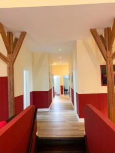 einen Flur mit roten und weißen Wänden und Holzbalken in der Unterkunft Gut Aspern Polohof in Barmstedt