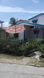 una casa con una sombrilla rosa delante de ella en Blue Ocean Village, en San Andrés