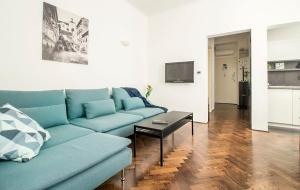 uma sala de estar com um sofá azul e uma mesa em BASTINICA Superior Apartment, OLD TOWN in City CENTER em Zagreb