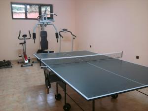 a ping pong table in a room with two exercise bikes at Villa Prolet in General-Kantardzhievo