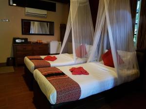 two beds in a room with mosquito nets at Ombak Dive Resort Perhentian Island in Perhentian Islands