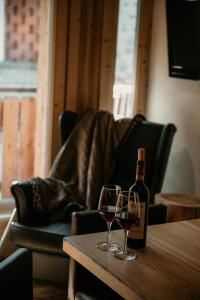 Una botella de vino y dos copas en una mesa. en Alpen Hotel Chalet, en Valdidentro