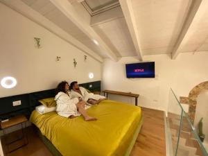 a man and woman sitting on a bed in a room at Suite61 in Altamura