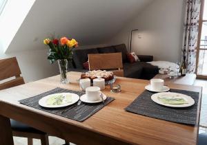 uma mesa com dois pratos e um bolo em Landhof Sedlmair em Gilching