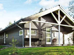 una pequeña casa con techo de gambrel en 6 person holiday home in Hadsund en Odde