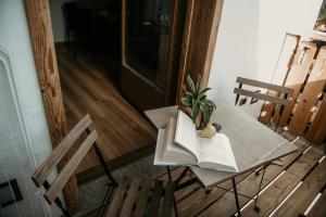 una mesa con un libro abierto y una planta en ella en Alpen Hotel Chalet, en Valdidentro