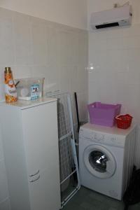 a laundry room with a washing machine and a washer at Apartment MIS Floura in Rijeka