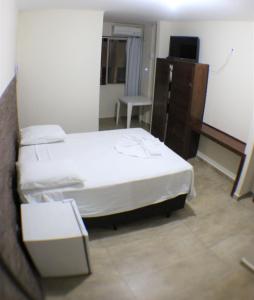 1 dormitorio con 1 cama, escritorio y TV en Novo Hotel Douglas, en Balneário Camboriú