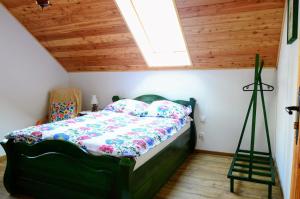 ein Schlafzimmer mit einem grünen Bett und einem Dachfenster in der Unterkunft Uroczysko Lubiaszów in Nowy Lubiaszów