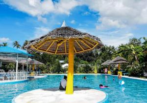 un grupo de personas en la piscina de un complejo en SweetWater Resort, en Zamboanguita