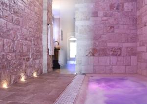 a hot tub in a room with a stone wall at Trulli e Puglia Luxury Suite in Alberobello +37 photos