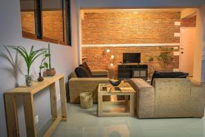 uma sala de estar com dois sofás e uma parede de tijolos em The Pines Serviced Apartments em Patan